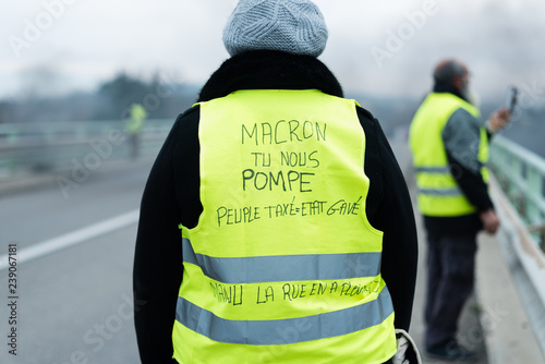 Une gilet jaune de dos avec une inscription pour macron - Manifestation en France photo