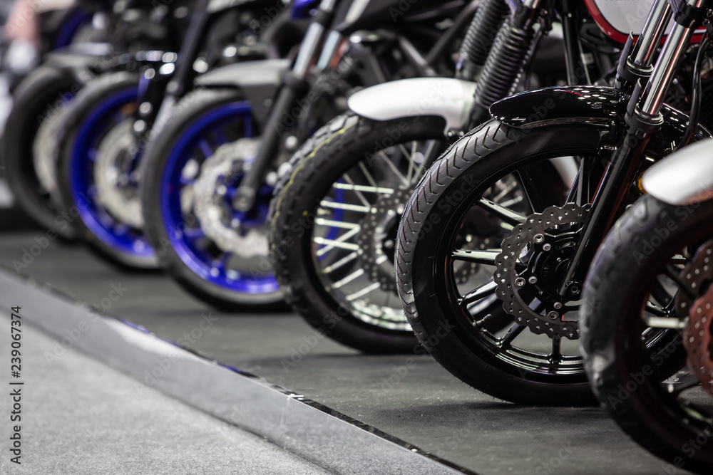 motorcycles parked on the motorcycles parking lot, Closeup of motorcycles front wheel. motorcycles parked on the motorcycles parking lot, Closeup of motorcycles front wheel.