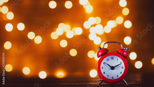 Vintage alarm clock and Fairy Lights on background