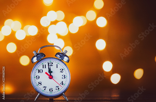 Vintage alarm clock and Fairy Lights on background