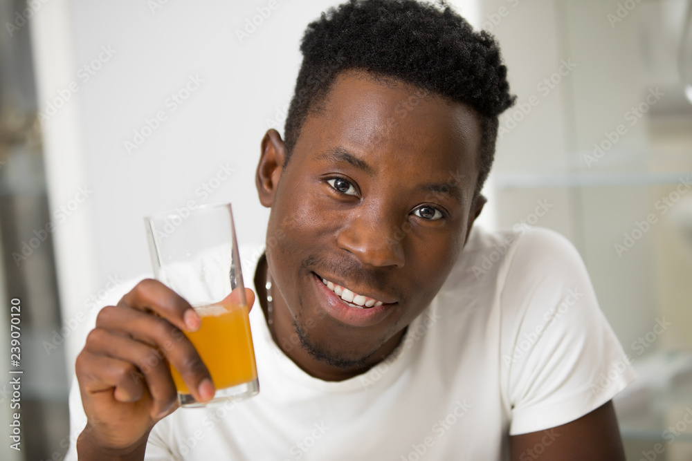 African american man drinking juice in kitchen African american man drinking juice in kitchen