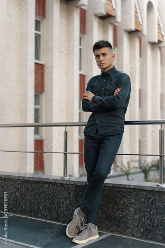 Portrait of a handsome young casual guy posing on street backgro photo