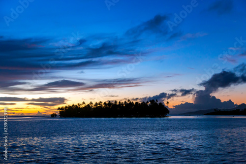 Orange-blue sunset over little island in the Pacific ocean, French Polynesia. © Tanya Keisha