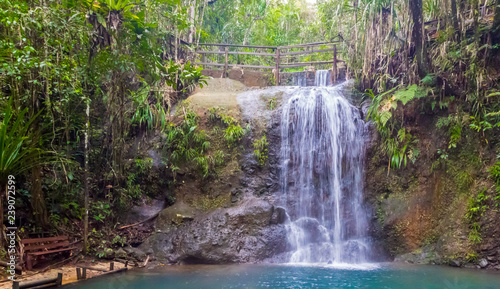 A bench at the end of hiking trail to enjoy a waterfall in Colo-i-Suva rain forest national park, nature reserve near Suva, Viti Levu island, Fiji, Melanesia, Oceania. photo