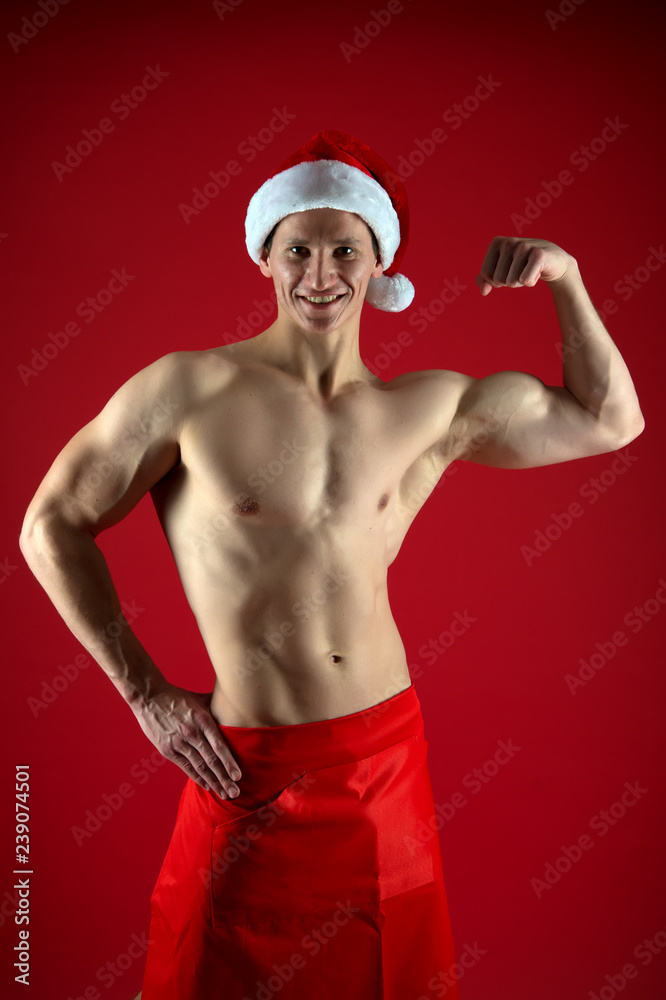 Christmas shopping. New year party. Santa claus man. Happy winter holidays. Red. Present for Xmas. Sexy muscular man in santa hat. Strong biceps. Bright memories. Christmas is the time to please