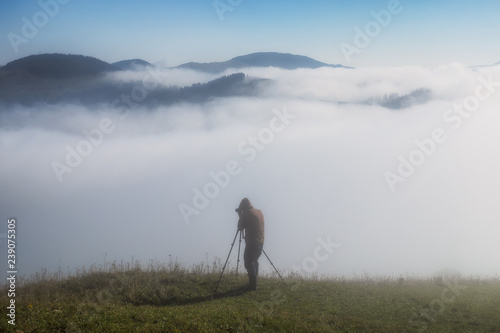 tourist in the mountains. photographer takes a sunrise in the mountains
