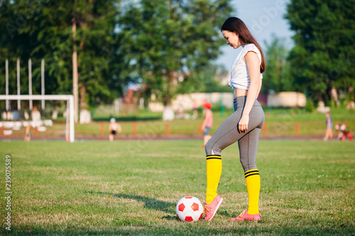 young woman kicking soccer ball