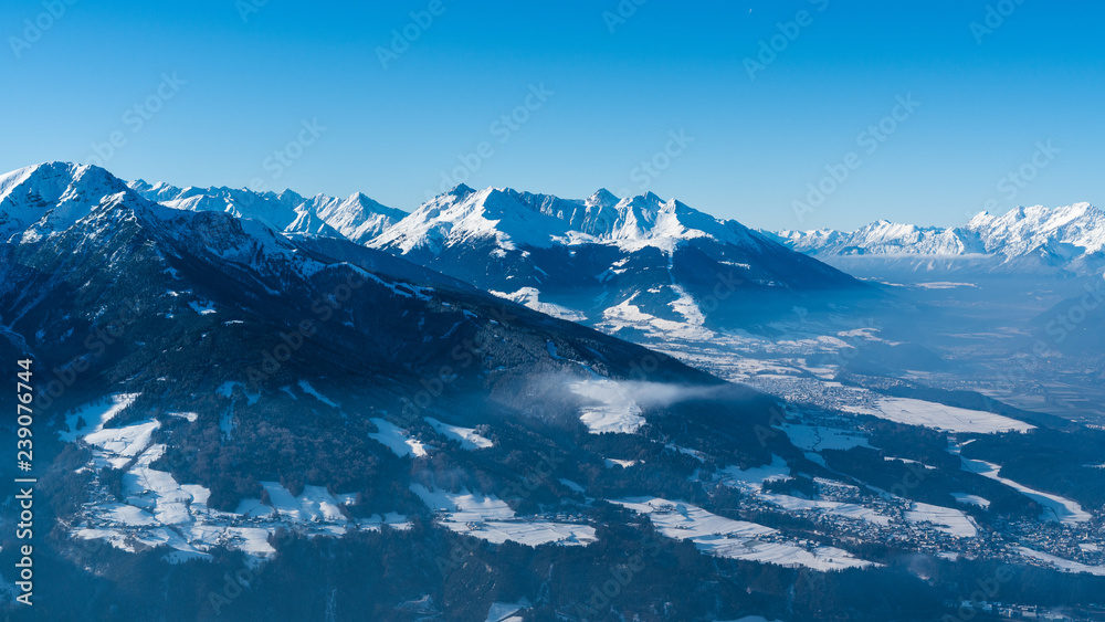 snow covered mountains with blue sky and som mist