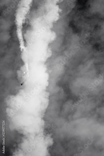 acrobatic plane in smoke and clouds