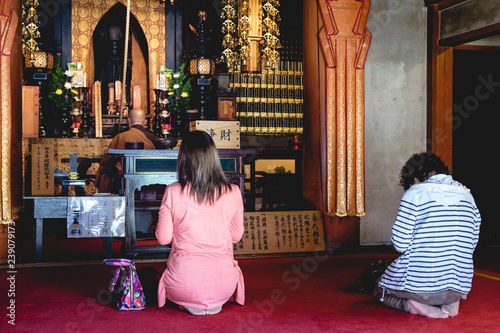 Woman praying at Shitennoji temple, osaka, japan photo