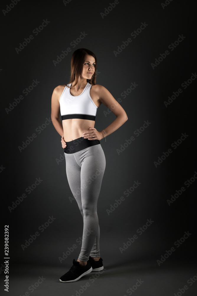 Happy young woman in sports clothing smiling