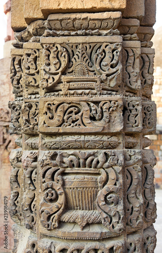 Column with intricate stone carving in courtyard of  Qutub complex, Delhi, India