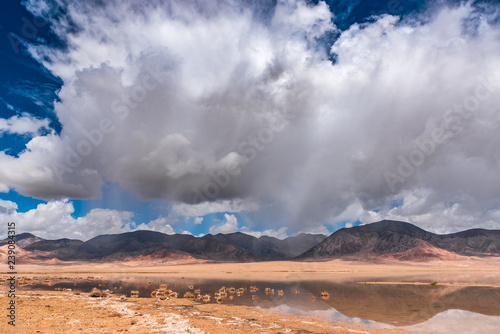 Top view of the mountain landscape. Stormy sky over the alpine lake. Reflection of rocks in the water. Beautiful nature.