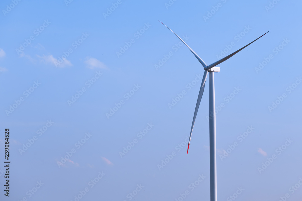 One single windmill turbine with blue sky in background. Renewable energy wind turbine One single windmill turbine with blue sky in background. Renewable energy wind turbine