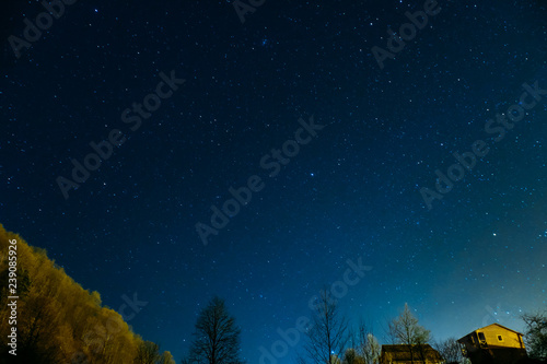 Night picturesque view. The wonderful starry sky s time and the majestic mountain range  with glowing villages below. Some digital noise due to high iso.