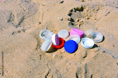 Fototapeta Naklejka Na Ścianę i Meble -  colored plastic caps abandoned on the beach