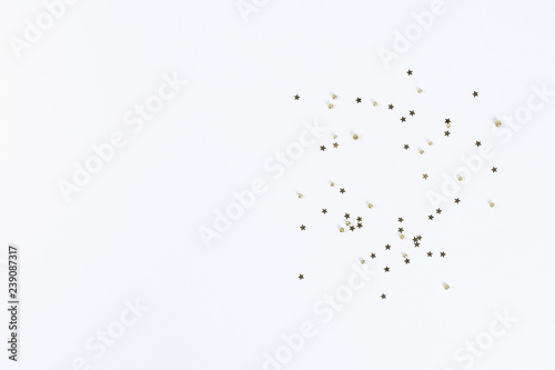 Christmas layout. Golden confetti in the form of stars on a white background. New Year 2019, christmas, winter concept. Copy space, tov view, flat lay composition. © detry26