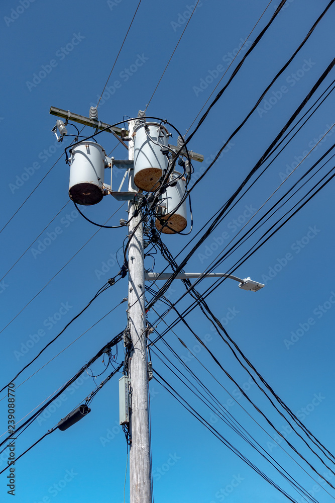 Electric urban wooden poles/ post with cables and three cylinder transformers. Electric urban wooden poles/ post with cables and three cylinder transformers.