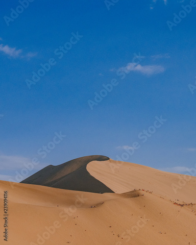 Sand dunes and desert under blue sky at Mingsha Mountain  in Dunhuang  Gansu  China