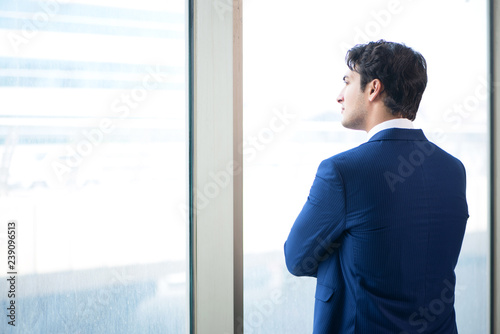 Young handsome businessman standing at the window Free Download Young handsome businessman standing at the window - GFXLoad