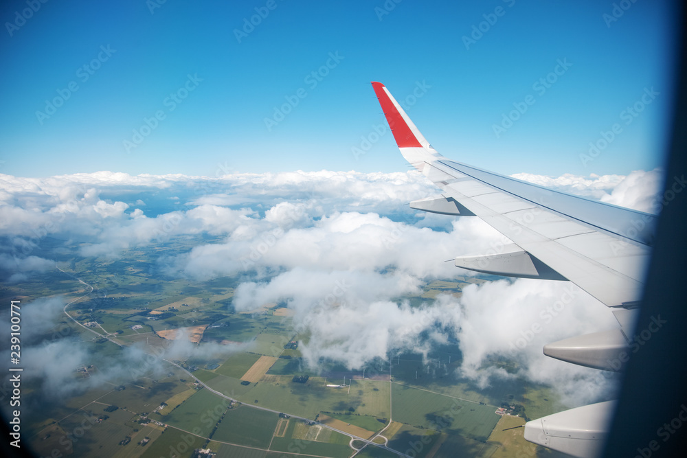 View from the window of the plane to the fields and clouds, air travel concept background View from the window of the plane to the fields and clouds, air travel concept background