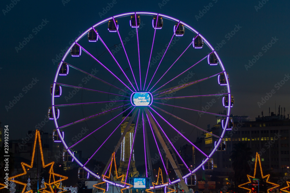 Lisbon, Portugal - Circa December 2018: Ferris wheel in Christmas fair at dusk