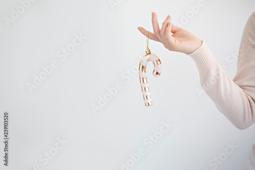 hand holding a gold candy cane on white background