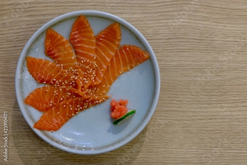 Salmon sashimi with white plate on wood background