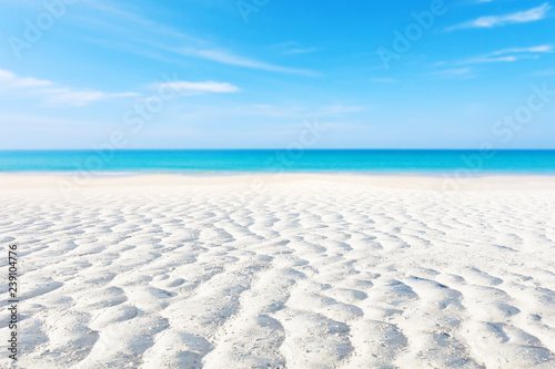 White sand curve or tropical sandy beach with blurry blue ocean and blue sky background image for nature background or summer background