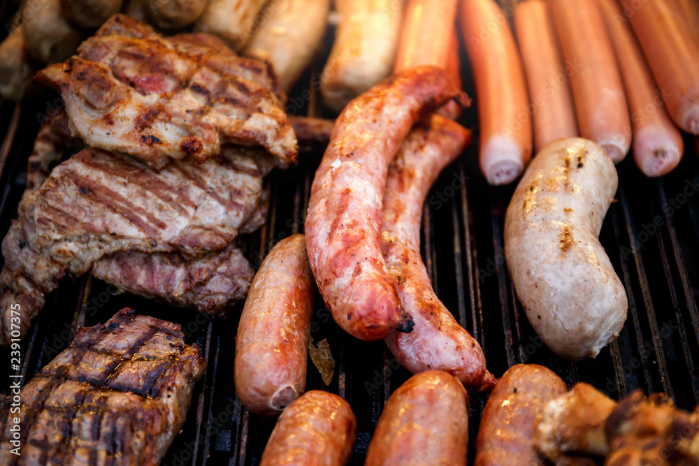 Closeup of mixed grilled sausages and barbecue steak on the grill Closeup of mixed grilled sausages and barbecue steak on the grill