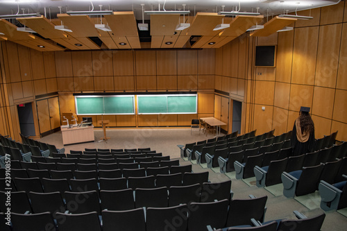 University graduation - a grad in an empty lecture hall