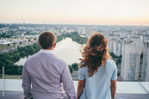 loving couple standing on the roof and watching on the city © Evgeny