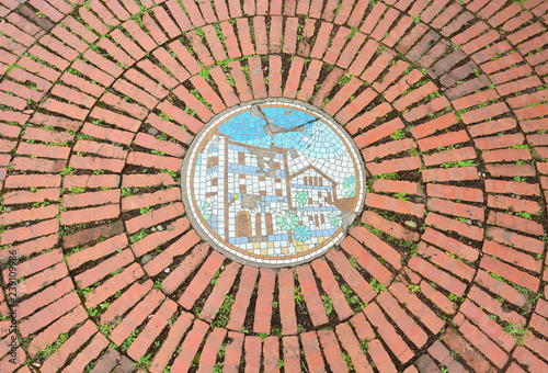 red brick pavement in public park, a circular of old red brick floor pattern background texture with mosaic picture in the middle, Taipei, Taiwan