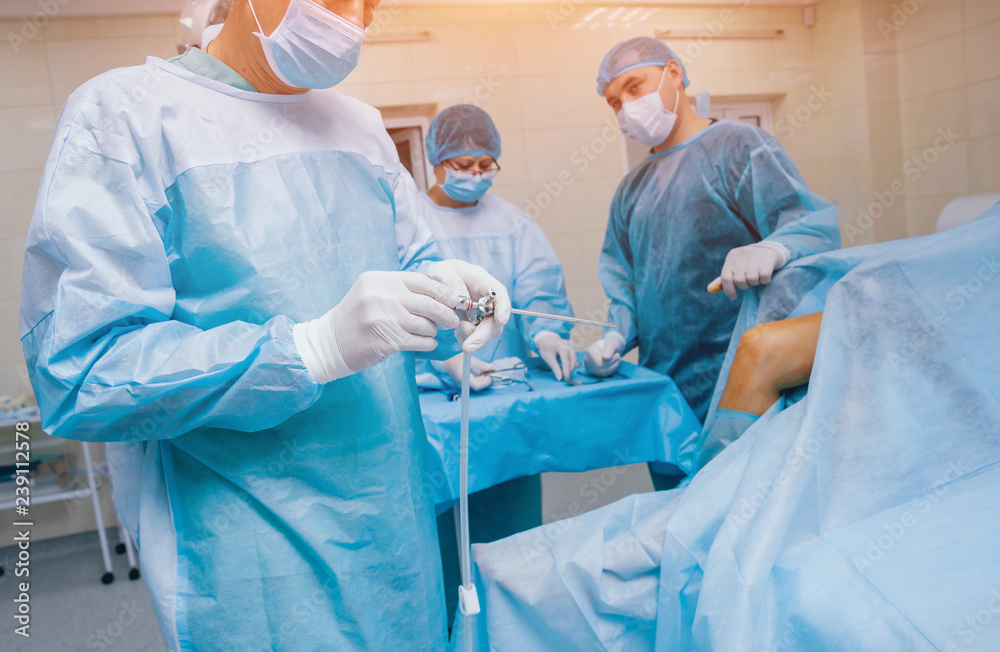 Arthroscope surgery. Orthopedic surgeons in teamwork in the operating room with modern arthroscopic tools. Knee surgery. Arthroscope surgery. Orthopedic surgeons in teamwork in the operating room with modern arthroscopic tools. Knee surgery.