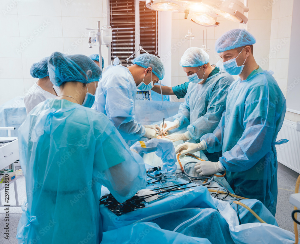 Process of gynecological surgery operation using laparoscopic equipment. Group of surgeons in operating room with surgery equipment Process of gynecological surgery operation using laparoscopic equipment. Group of surgeons in operating room with surgery equipment