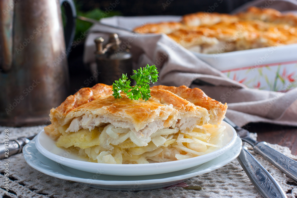 Sliced puff pastry cake with chicken, potatoes and onions, selective focus Sliced puff pastry cake with chicken, potatoes and onions, selective focus