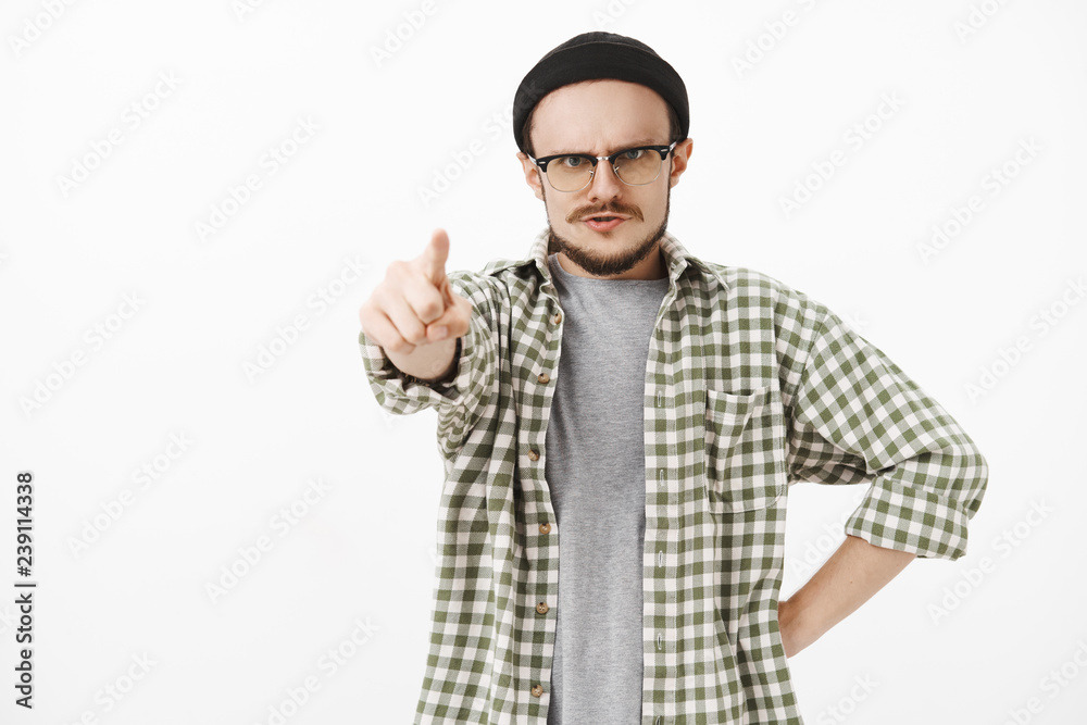 You guilty. Serious-looking strict, irritated young male music teacher in black beanie and glasses with moustache standing in furious pose pointing at camera dissatisfied blaming student You guilty. Serious-looking strict, irritated young male music teacher in black beanie and glasses with moustache standing in furious pose pointing at camera dissatisfied blaming student