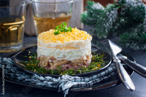 Salad in layers with canned mushrooms, smoked chicken and cheese on a black plate, horizontal