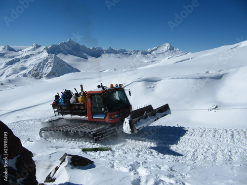 Mountain ratrak carries snowboarders and skiers on the high slope of the mountain