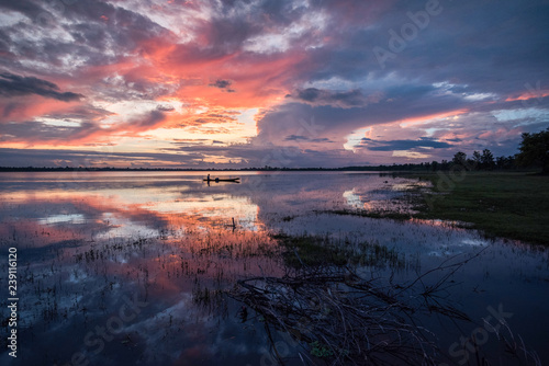 Fototapeta Naklejka Na Ścianę i Meble -  fisherman on boat on the lake fisherman silhouette sunrise or sunset on river colorful twilight