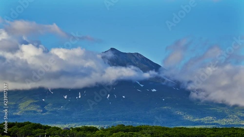 Kuril islads. Summer landscape with white cloud, fog and old vulkane. photo