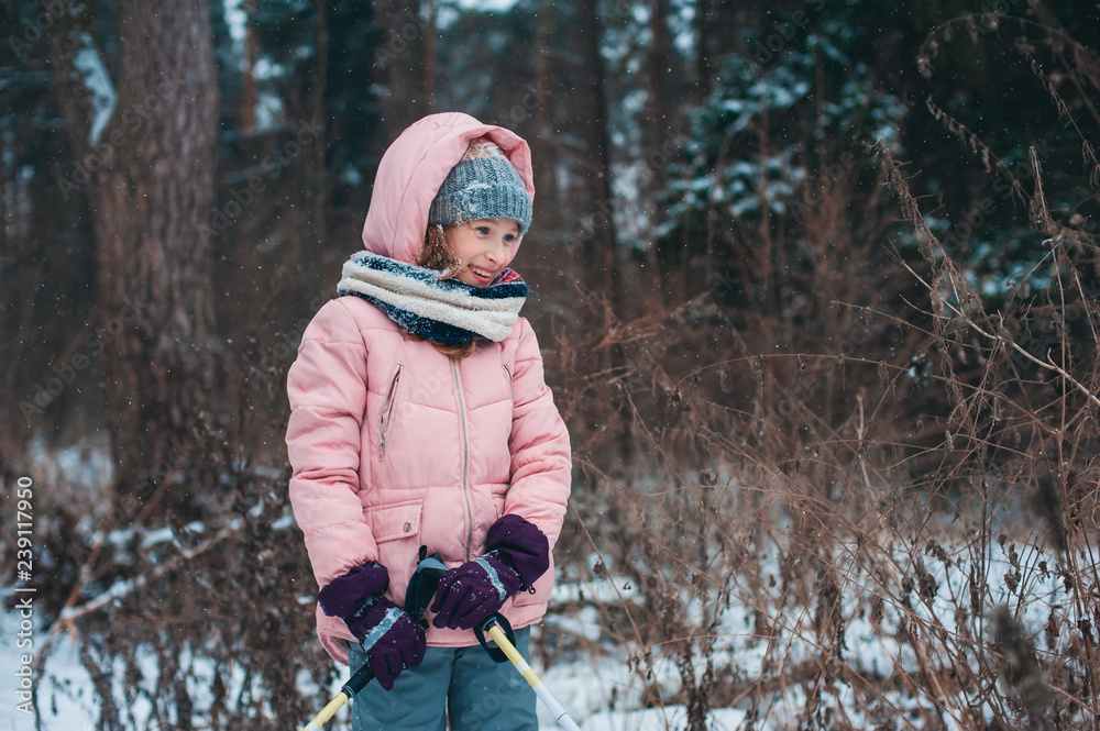 happy child girl skiing in winter snowy forest, spending holidays outdoor. Active winter sports. happy child girl skiing in winter snowy forest, spending holidays outdoor. Active winter sports.
