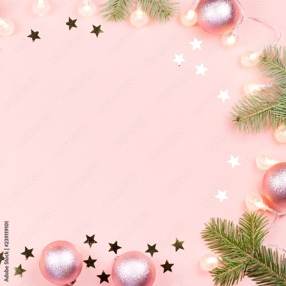 Christmas background with fir branches, lights, pink decorations on pink Christmas background with fir branches, lights, pink decorations on pink
