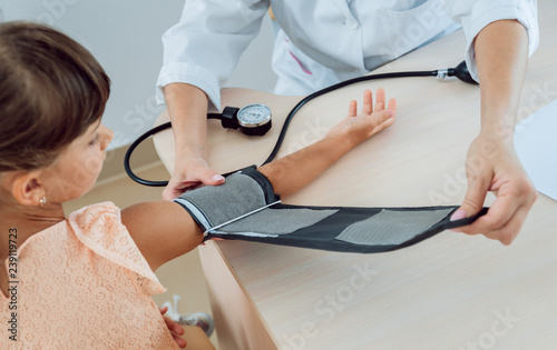 Doctor measuring blood pressure of a little girl. © romaset