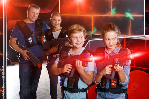 Happy boy and girl posing with laser guns