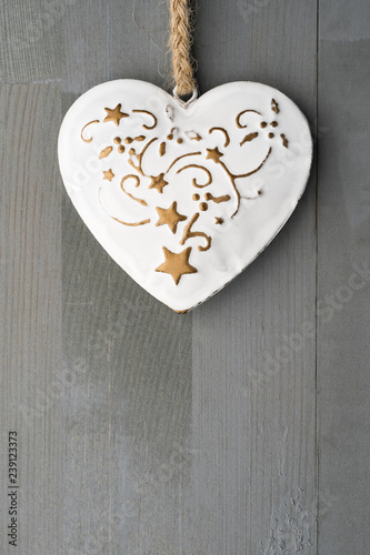 Festive heart shaped Christmas or New Year ornament with twine. Grey background. Vertical orientation. Copy space on the bottom.