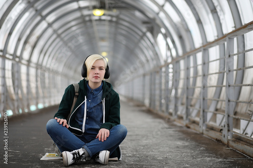 Young girl listens to music in big headphones in the subway © alexkich