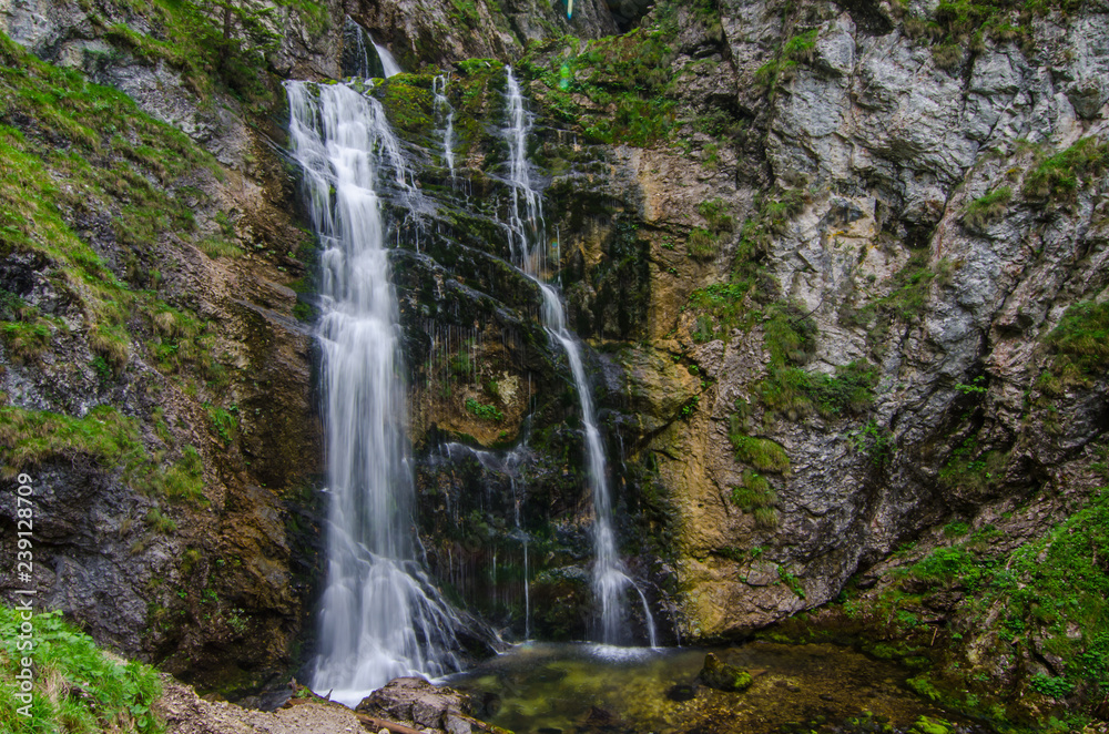 kleiner schoener wasserfall mit felsen