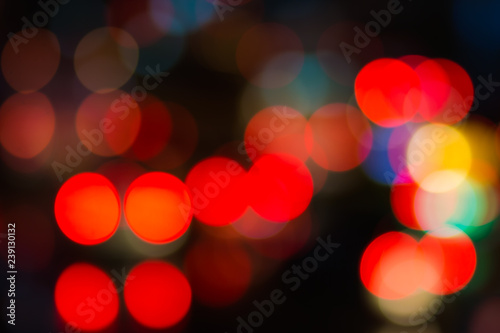 Abstract red bokeh lights on road street in city night light background, decoration in soft for greeting card backdrop with glitter sparkle blurred circles © smolaw11