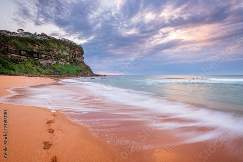 Waves wash on the seashore washing away footprints